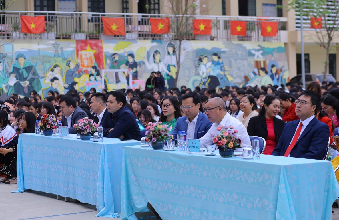 ''A group of people sitting at long tables

Description automatically generated''