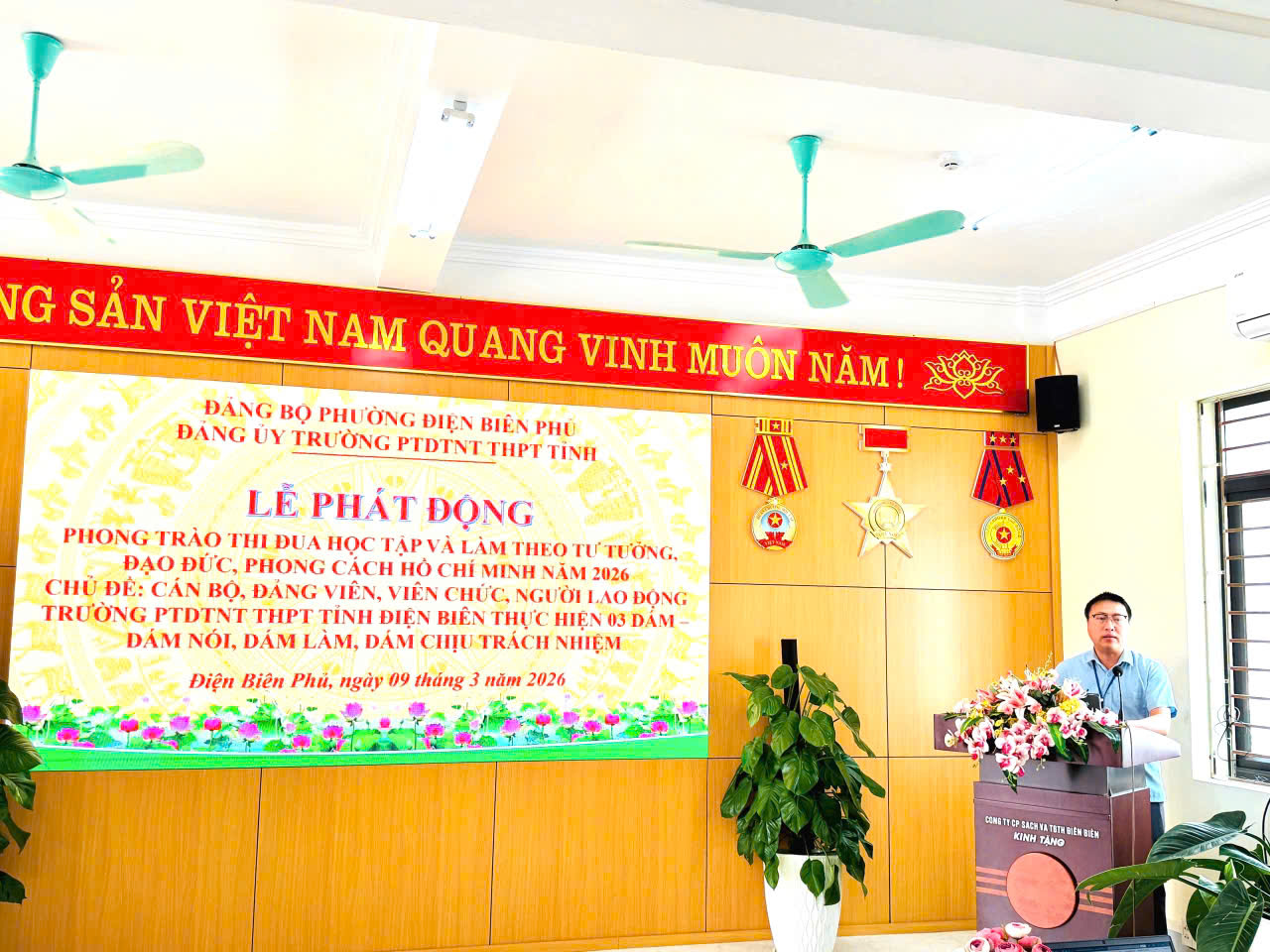 'A person standing at a podium

Description automatically generated'