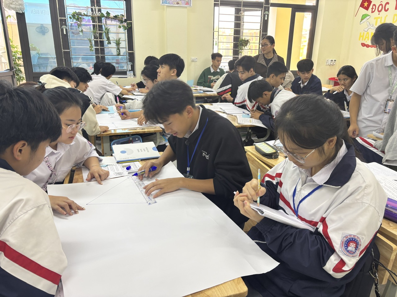 '''A group of people sitting at desks
Description automatically generated'''