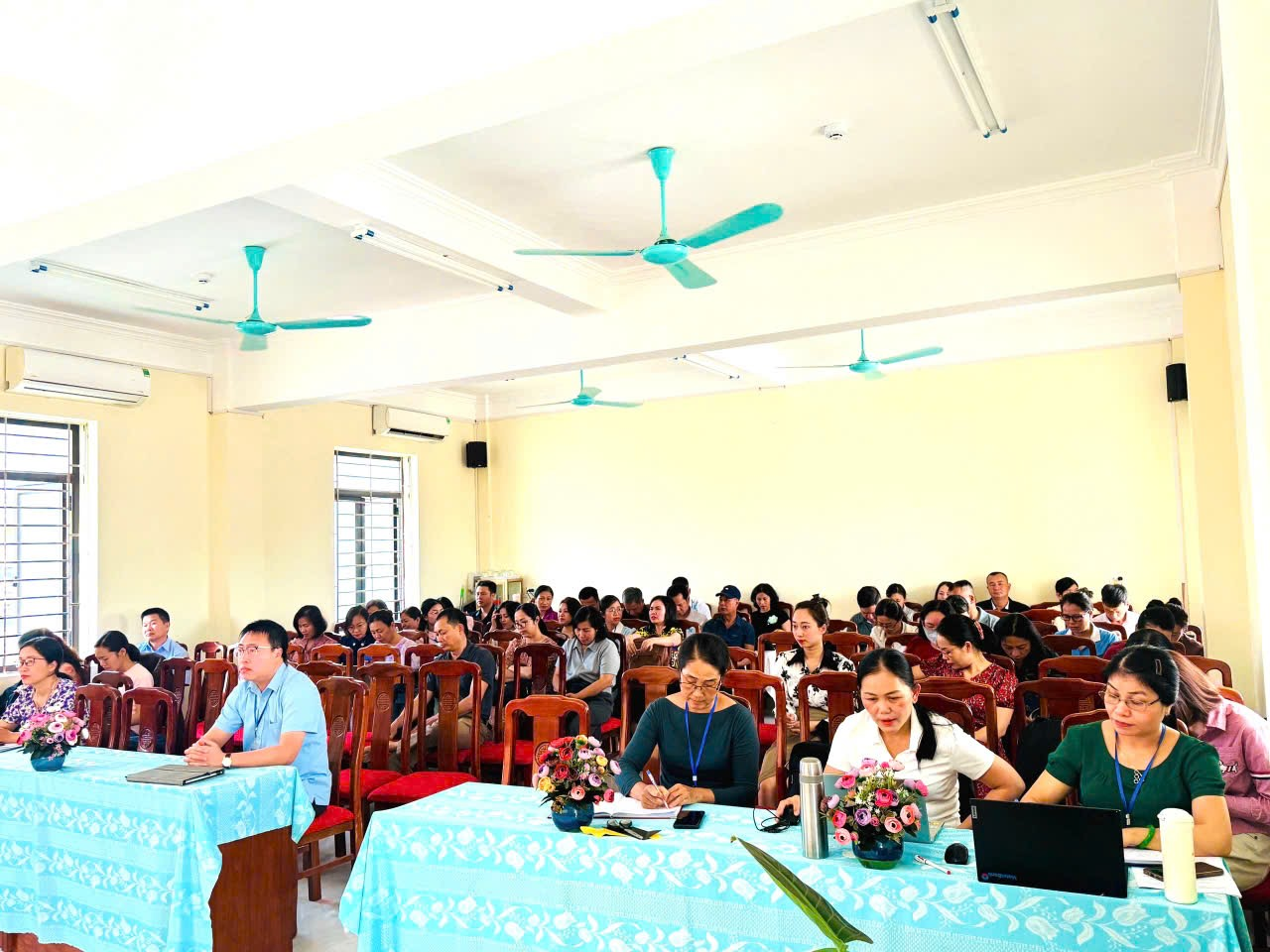 ''''A group of people sitting at tables in a room
Description automatically generated''''