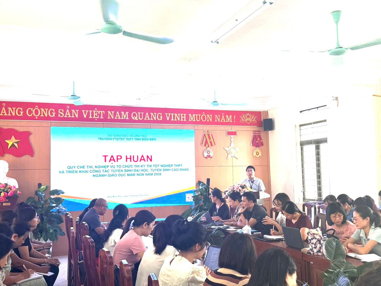 ''A group of people sitting in chairs in a room

Description automatically generated''