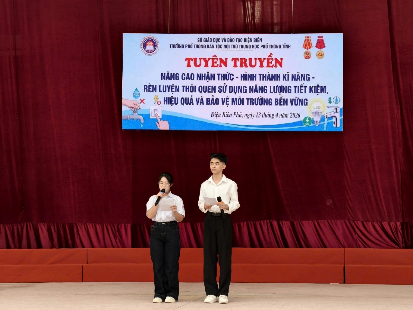 'A couple of people on a stage
Description automatically generated'