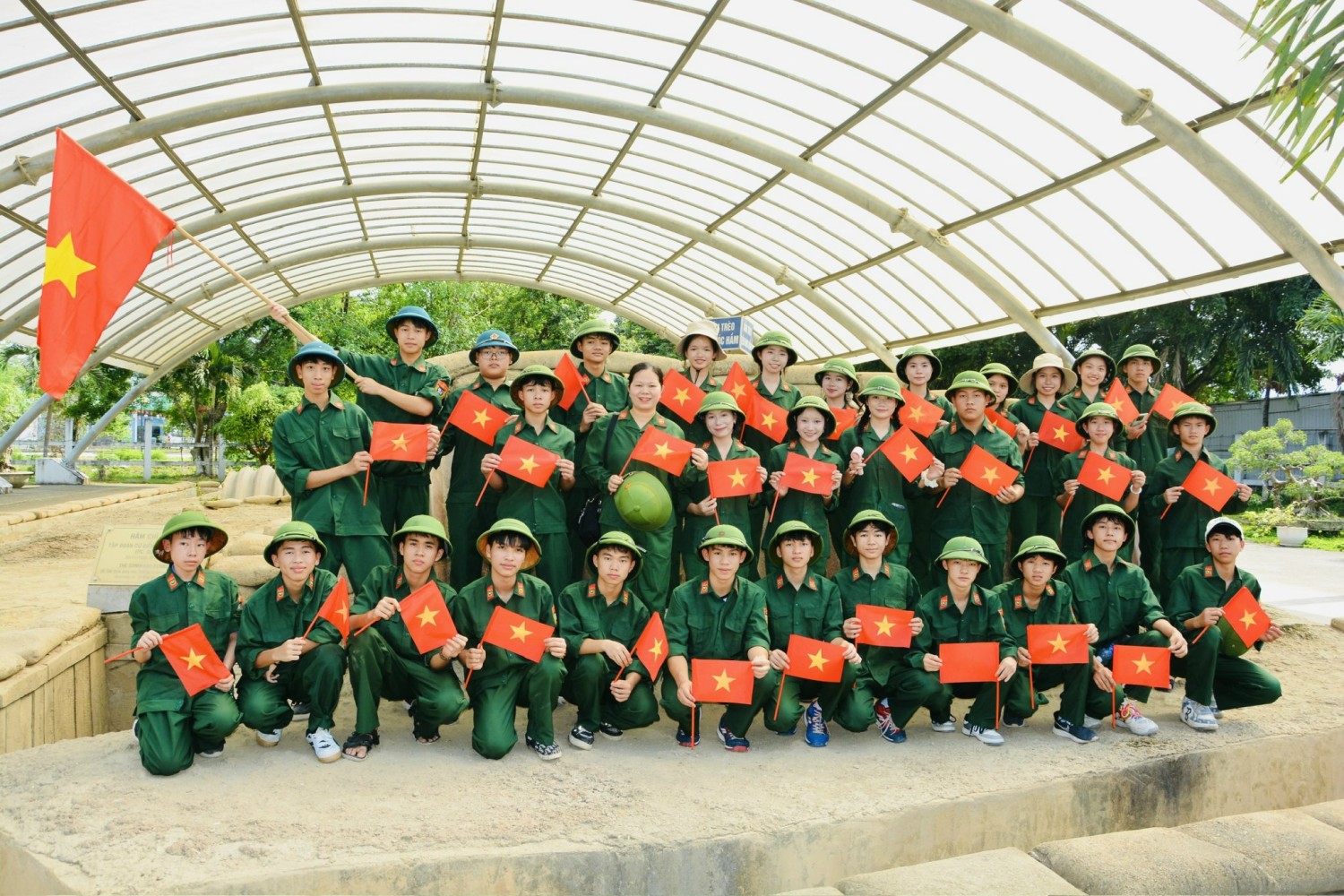 ''A group of people in green uniforms holding flags

Description automatically generated''
